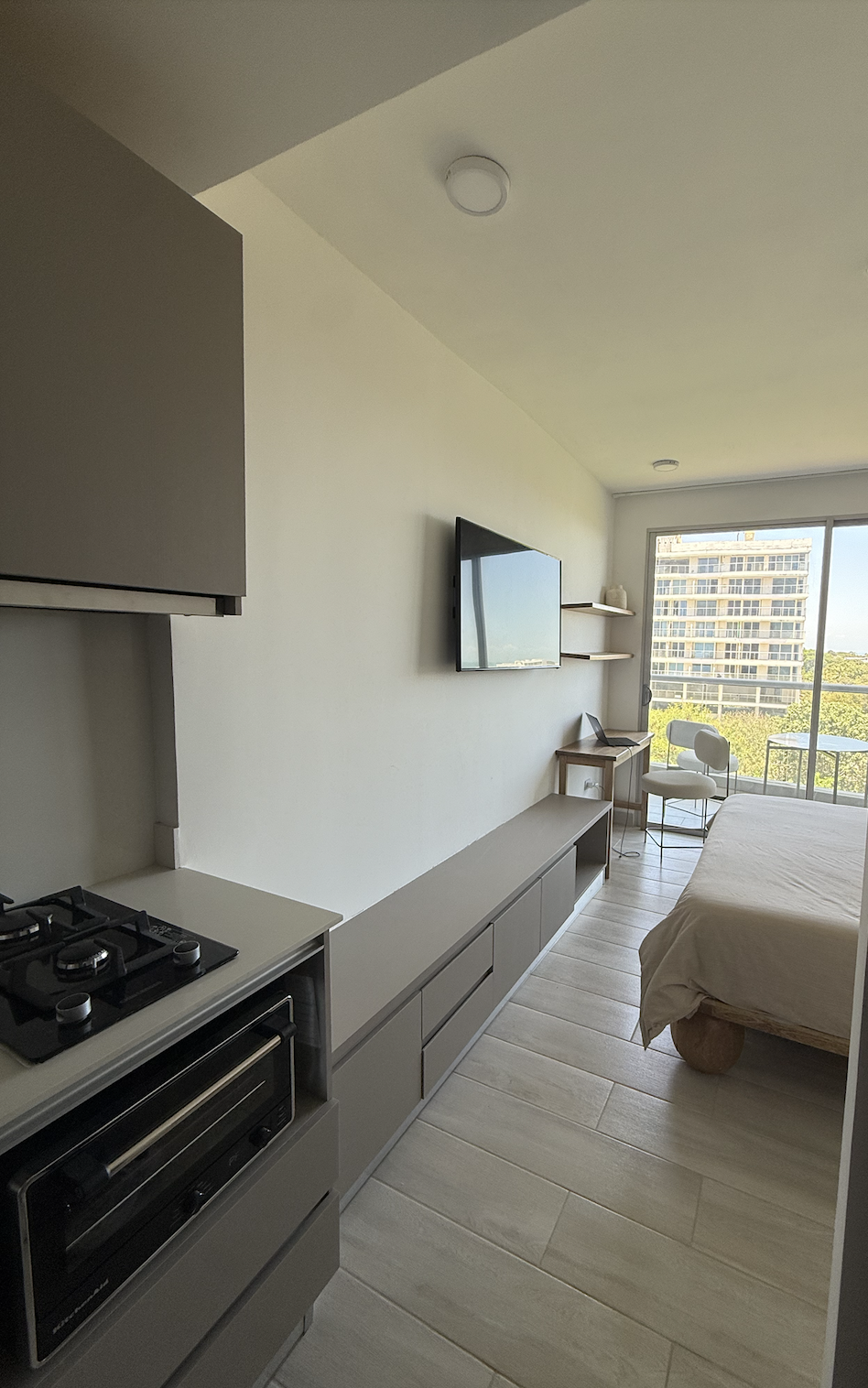 Vista integral del estudio con cama, TV y balcón