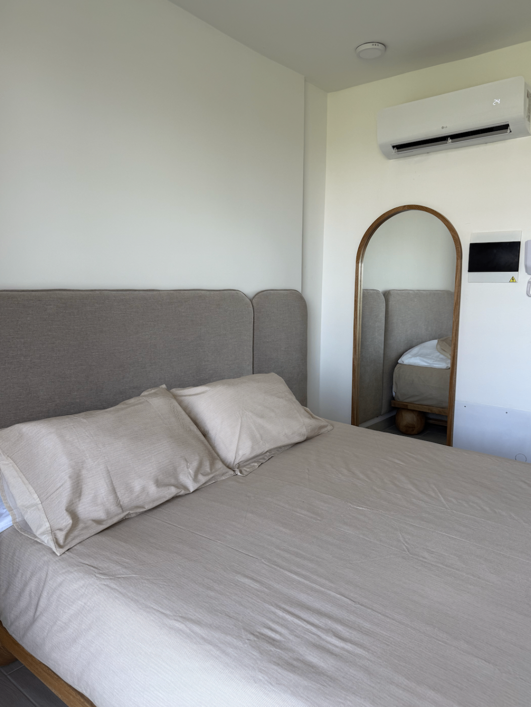 Detalle de la cama principal con espejo y aire acondicionado