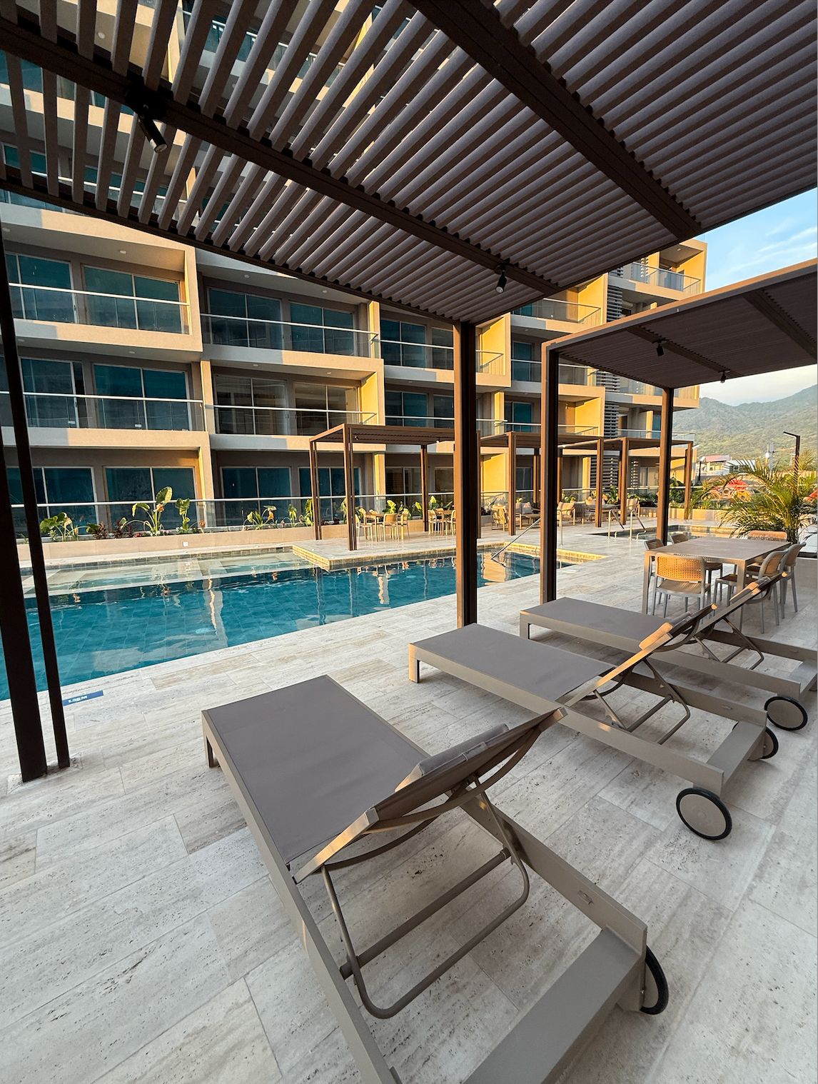 Zona de piscina con camastros y pérgolas